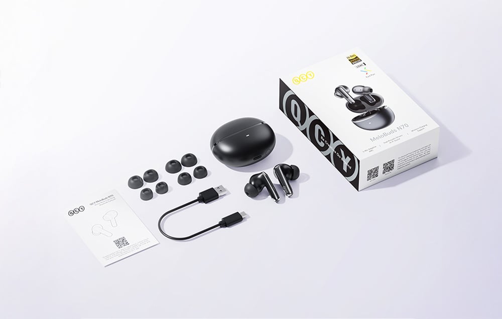 Zestaw słuchawek QCY z etui, wymiennymi nakładkami, kablem USB-C i pudełkiem produktowym rozłożony na jasnej powierzchni