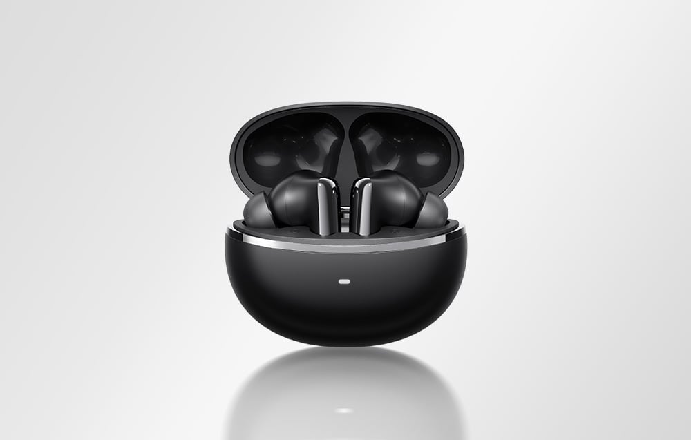 Czarne słuchawki bezprzewodowe umieszczone w otwartym, czarnym etui ładującym na jasnym tle.