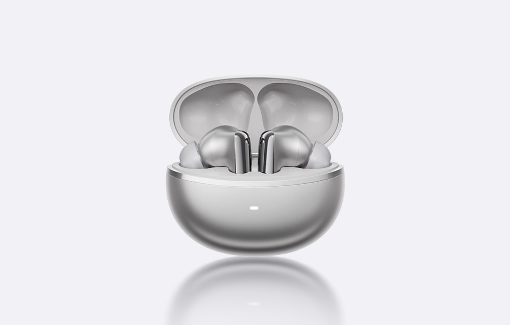 Srebrne słuchawki bezprzewodowe umieszczone w otwartym, dopasowanym kolorystycznie etui ładującym na jasnym tle