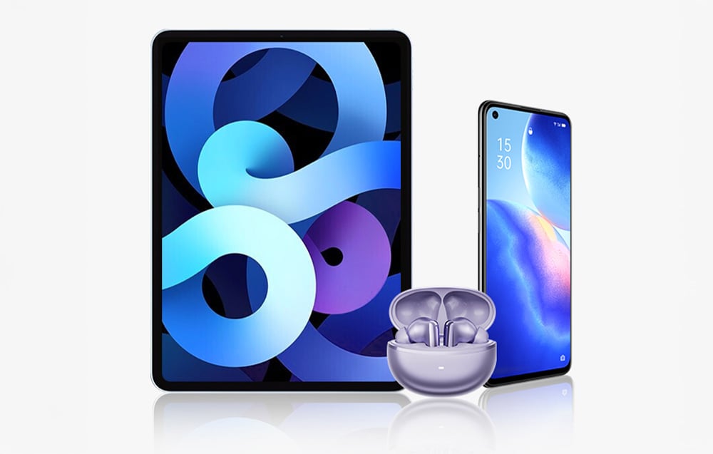 Fioletowe słuchawki bezprzewodowe w etui ustawione przed tabletem i smartfonem