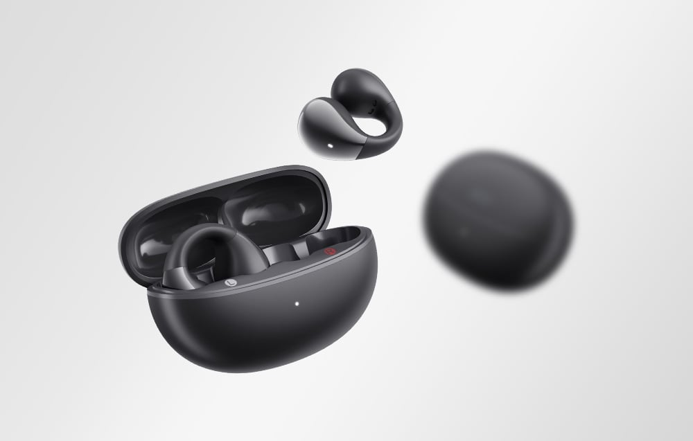 Czarne etui ładujące z jedną słuchawką unoszącą się w powietrzu i drugą rozmazaną w tle