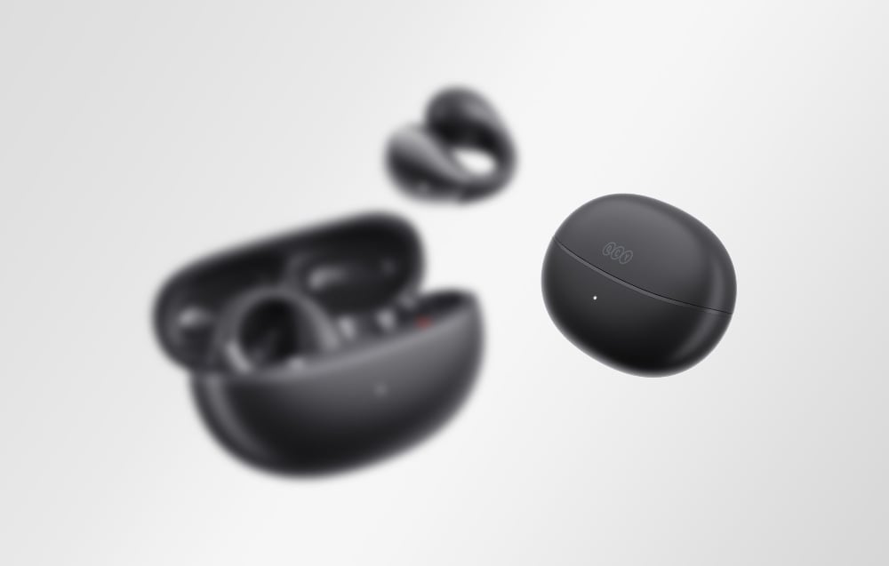 Etui słuchawek z zamkniętą pokrywą unoszące się obok rozmazanych słuchawek i drugiego otwartego etui