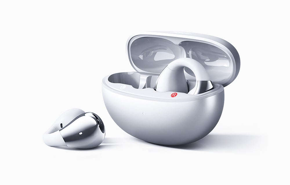 Etui QCY z jedną słuchawką wyjętą i drugą w środku, obie w kolorze srebrnym z chromowanym wykończeniem