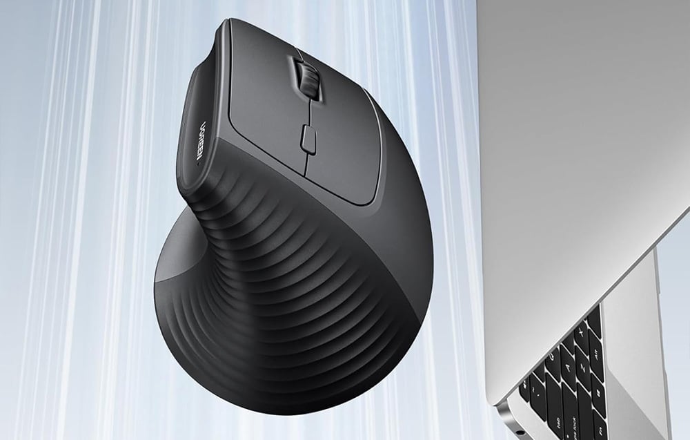 Czarna mysz pionowa Ugreen na niebieskim tle, obok laptop