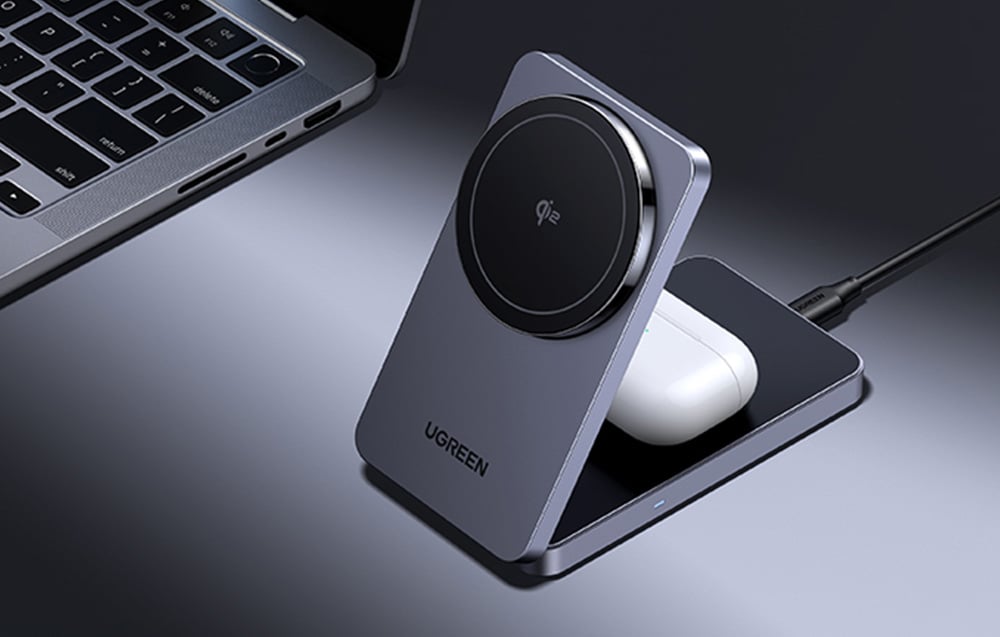 Ładowarka bezprzewodowa Ugreen z podłączonymi słuchawkami TWS na biurku obok laptopa