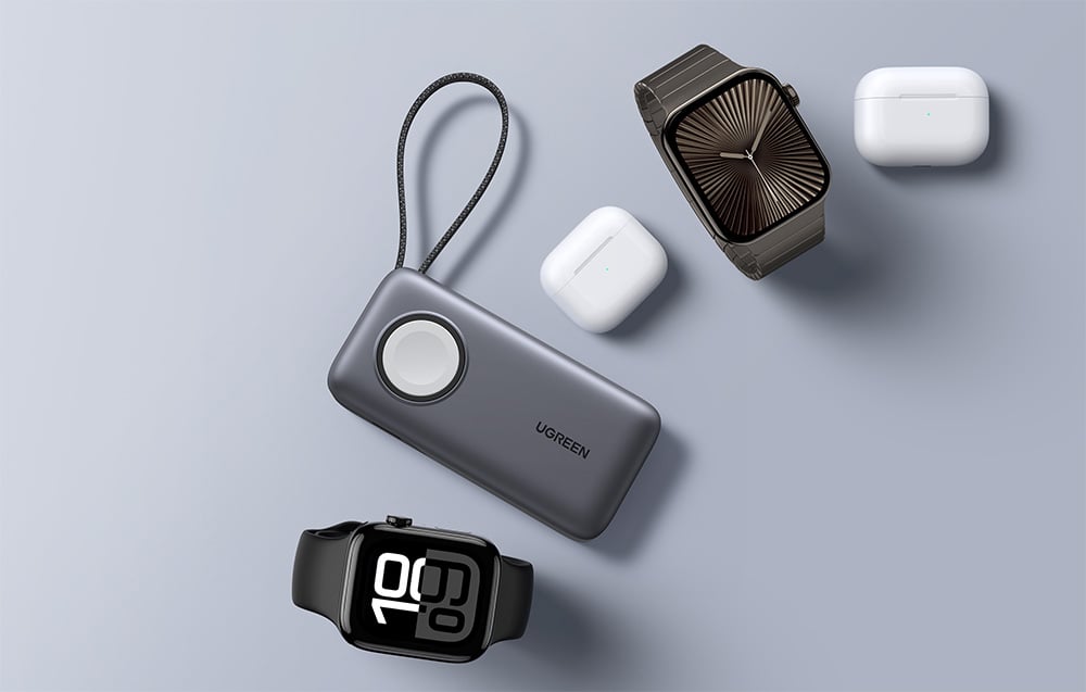 Grauer Ugreen-Powerbank liegt neben Smartwatches und TWS-Kopfhörern