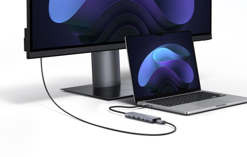 Laptop i monitor na białym stole podłączone ze sobą za pomocą huba 