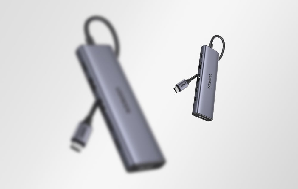 2 szare huby Ugreen z kablami USB-C na jasnym tle