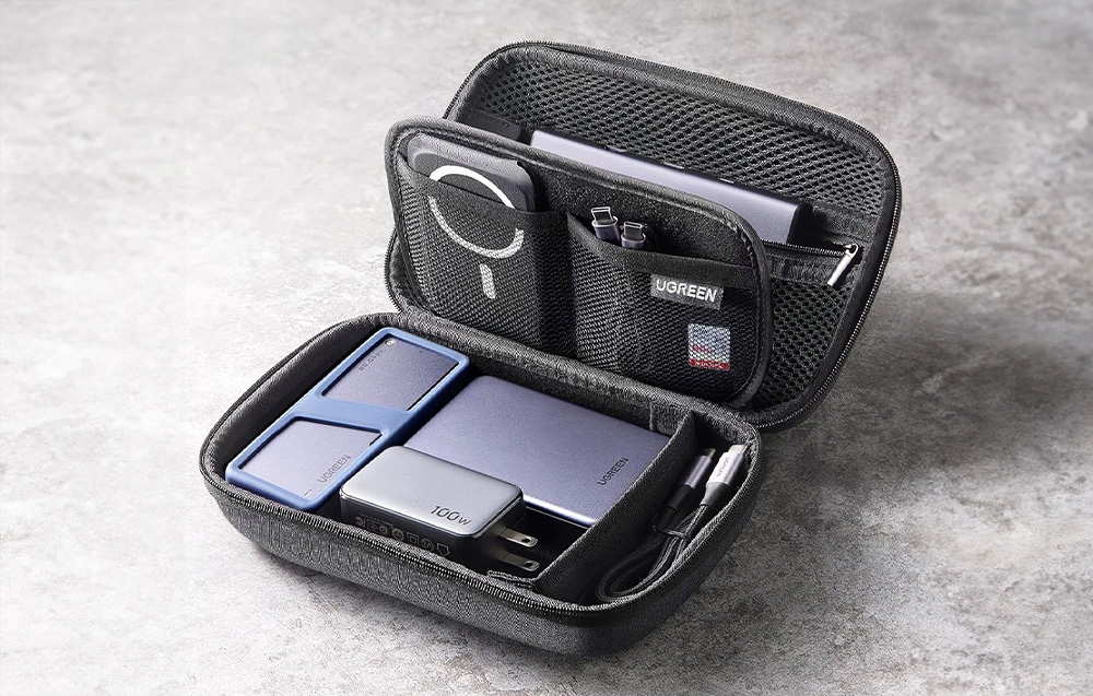 Travel organizer lying on a gray table, with Ugreen devices inside