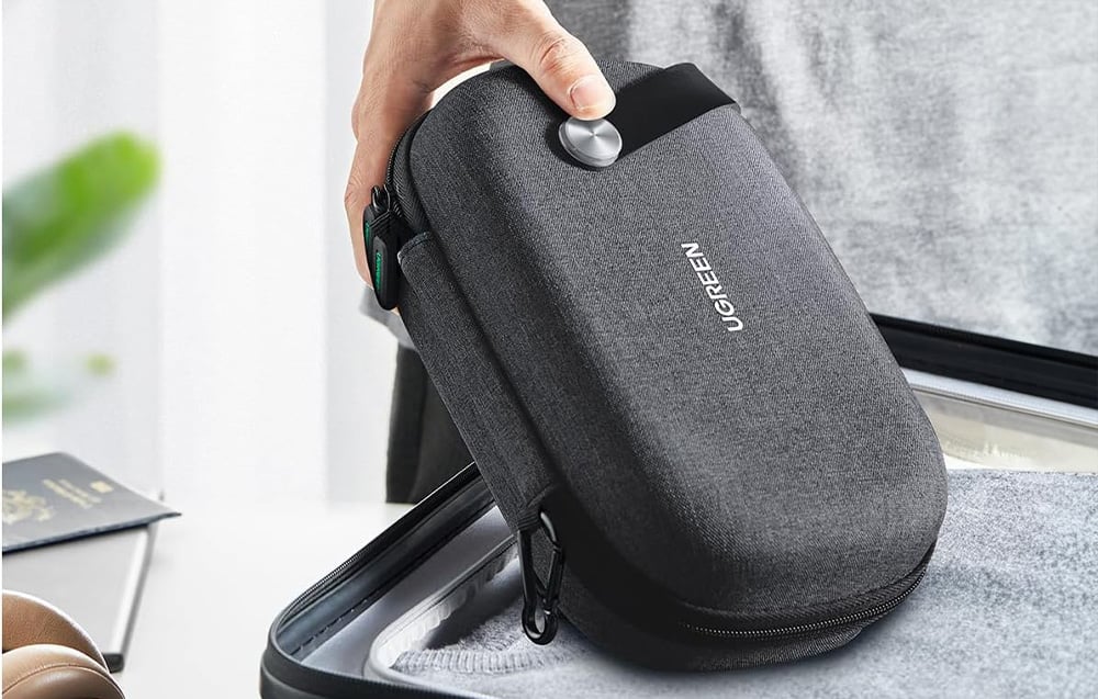 Travel organizer Ugreen held in hand, packed into a suitcase