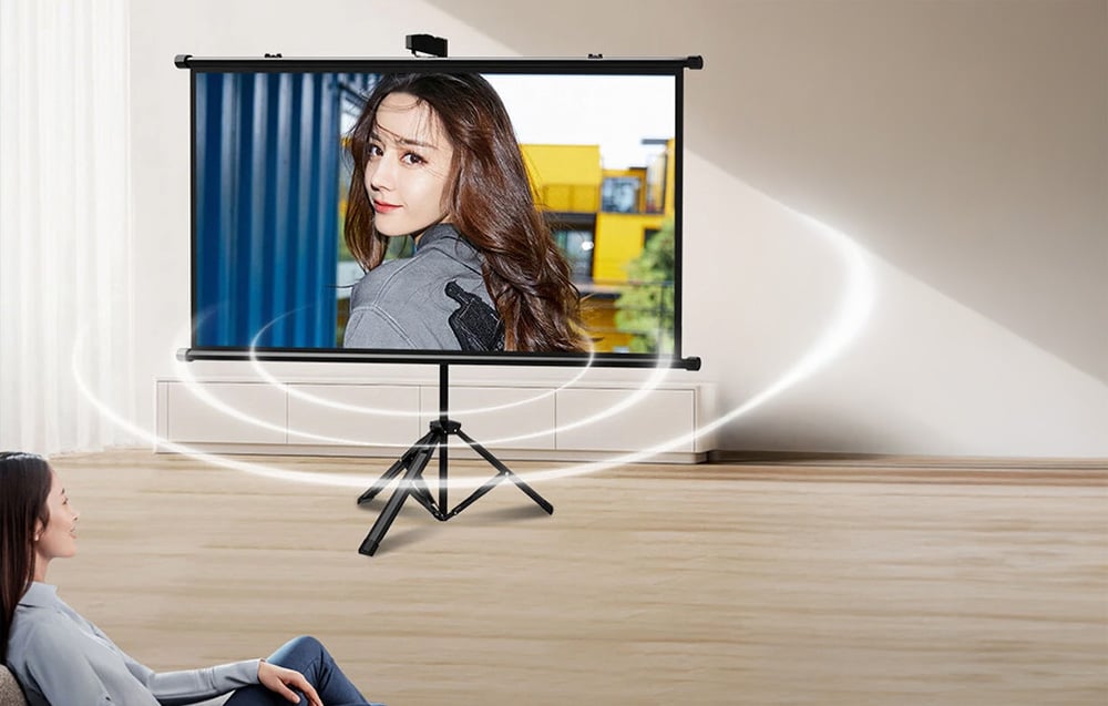 A woman sitting in a living room, watching multimedia displayed on the Blitzwolf BW-VS12 projector screen.