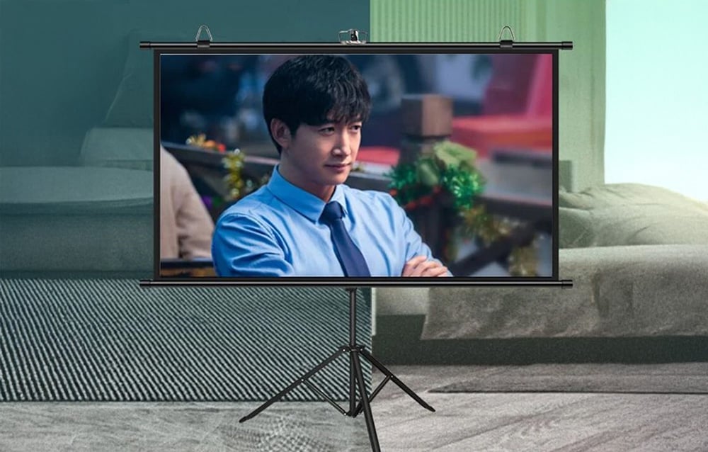 Blitzwolf BW-VS12 projector screen on a stand, displaying a movie, with a bedroom and living room in the background.