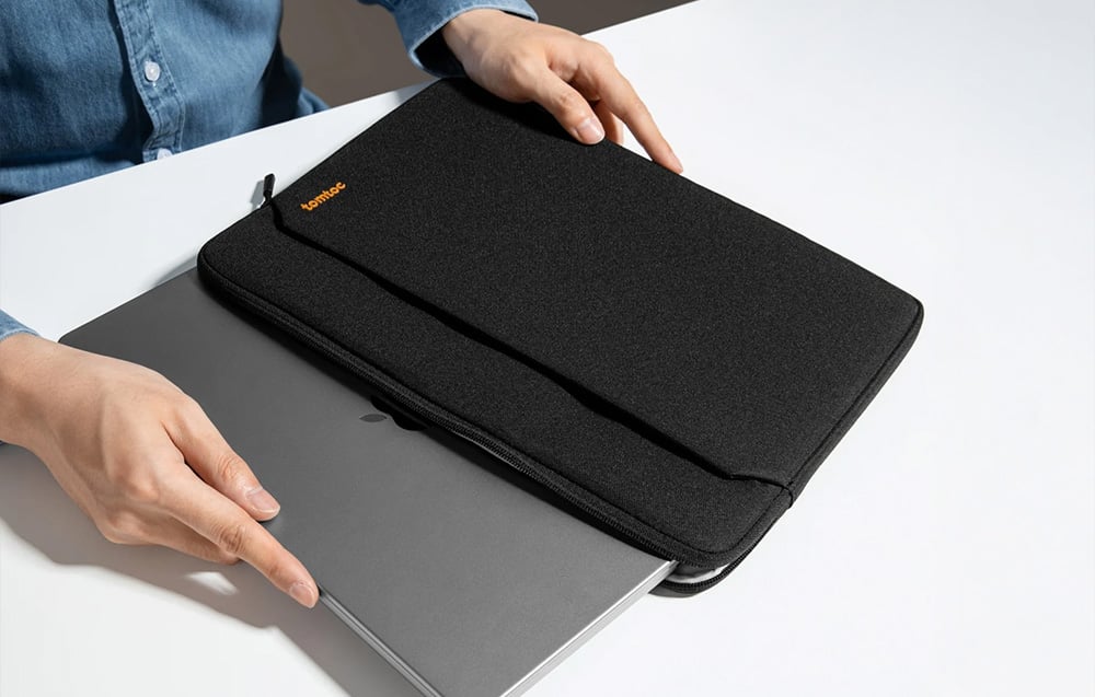A woman putting a laptop into a black sleeve