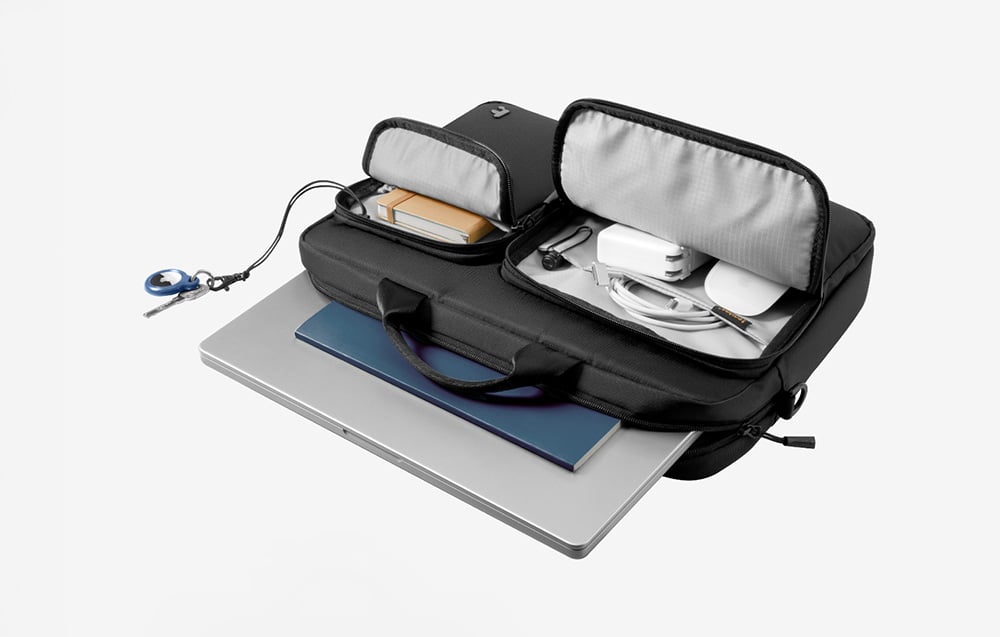 Czarna torba z laptopem i innymi akcesoriami wewnątrz