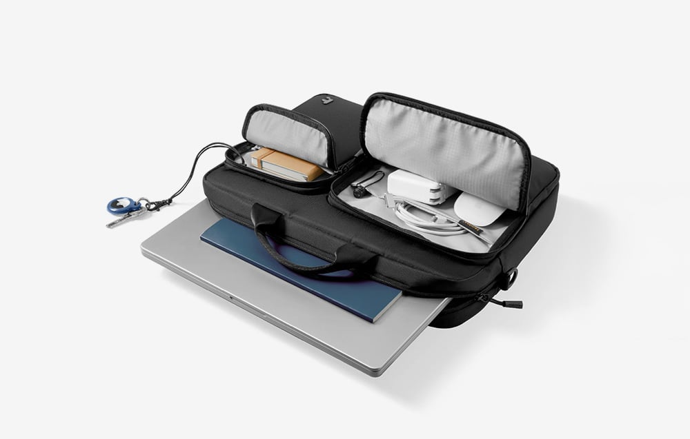 Czarna torba z laptopem i akcesoriami na białym tle