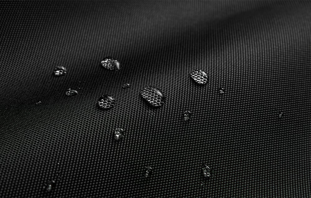 Close-up of the material of the black laptop bag with water droplets