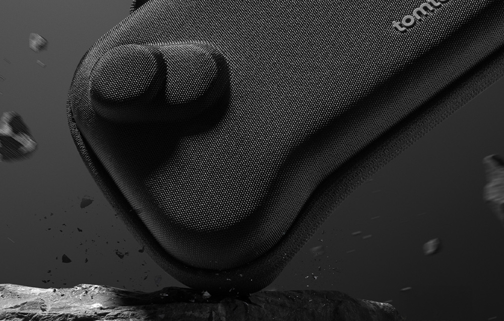 Close-up of a black tomtoc case for the console hitting a stone