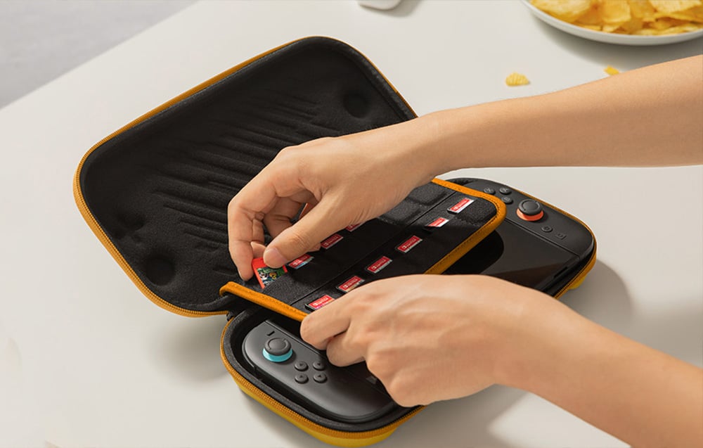 Osoba wkłada do etui z konsolą karty z grami