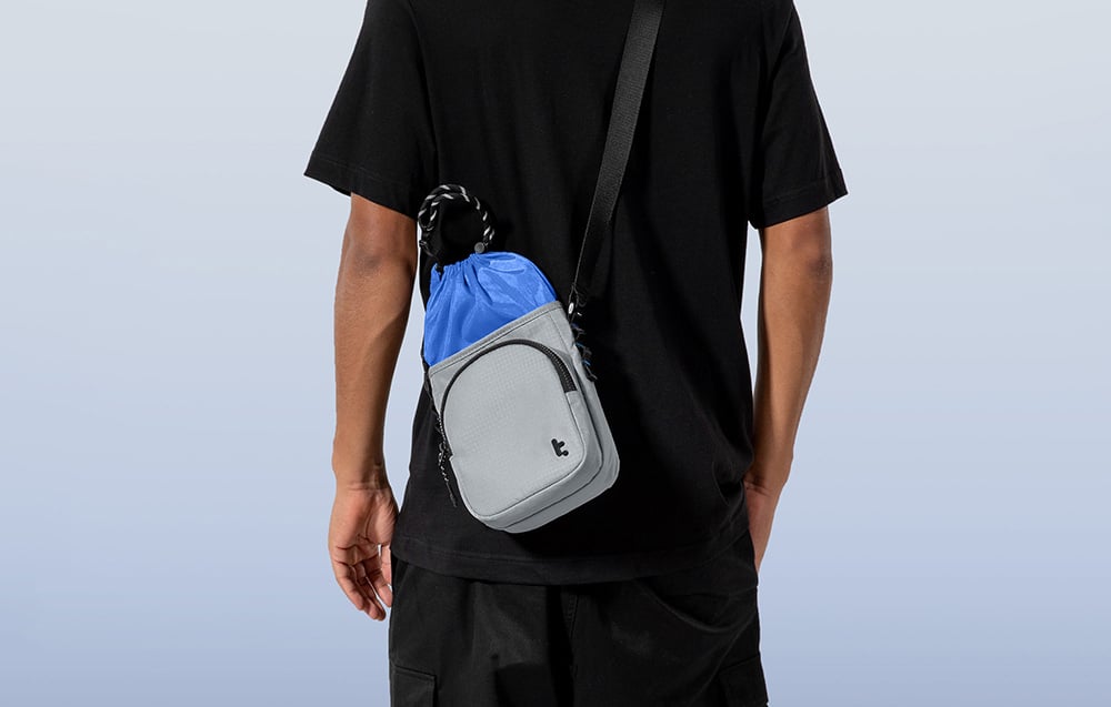 Szaro-niebieska torba na ramieniu mężczyzny w czarnym ubraniu