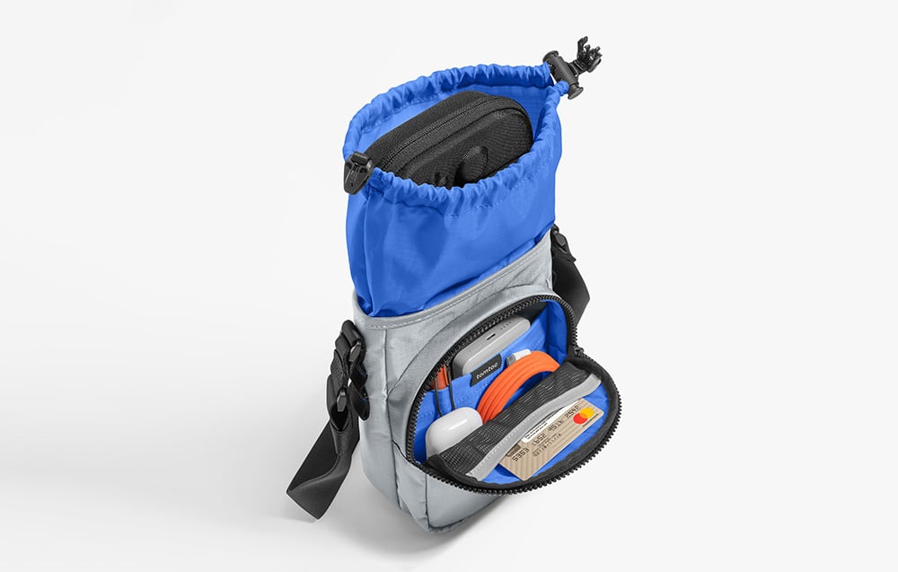 Szaro-niebieska torba z konsolą, słuchawkami i innymi drobiazgami