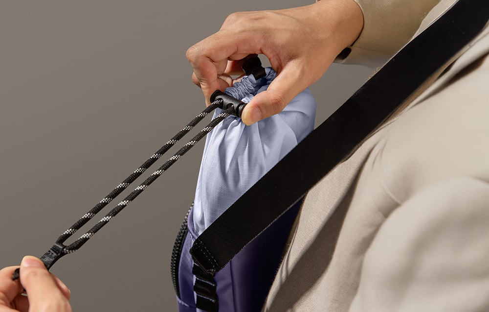 A person closing the bag using a special drawstring