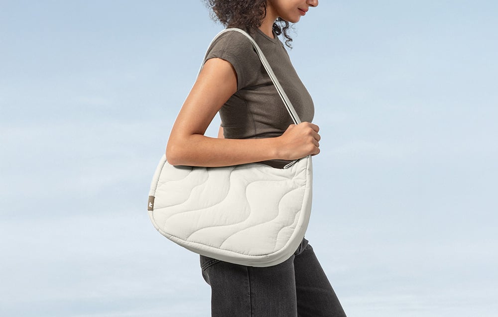 Frau in einem T-Shirt mit kurzer Ärmeln und einer weißen Umhängetasche