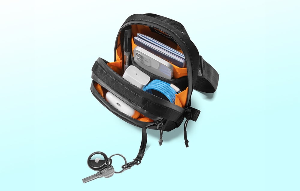 Black bag with smartphone, charger, and other accessories inside