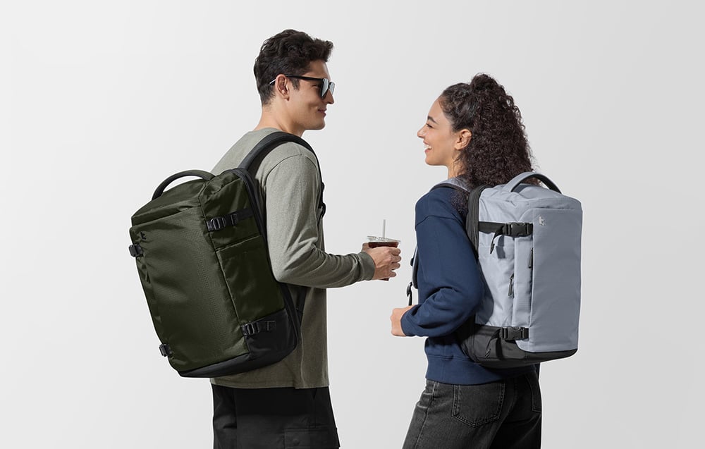 Kobieta i mężczyzna uśmiechają się do siebie, na plecach mają plecaki