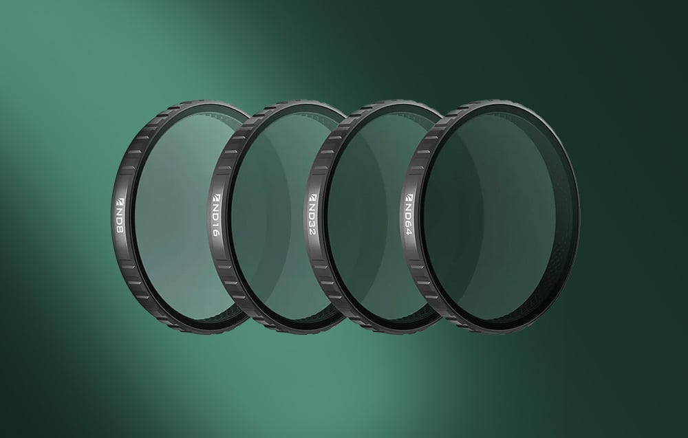 Zestaw czterech filtrów Freewell (ND8, ND16, ND32, ND64) ułożonych w rzędzie na zielonym tle.