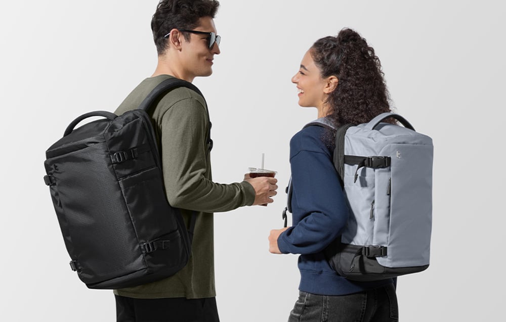A couple of people with Tomtoc Navigator T66 backpacks in black and gray colors