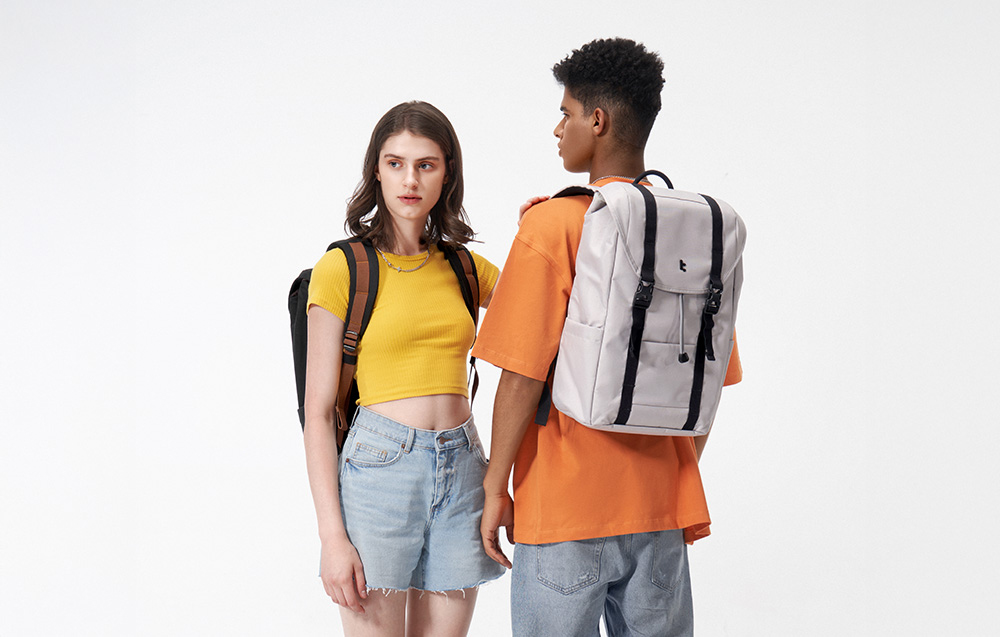 Hands putting a camera into a yellow backpack