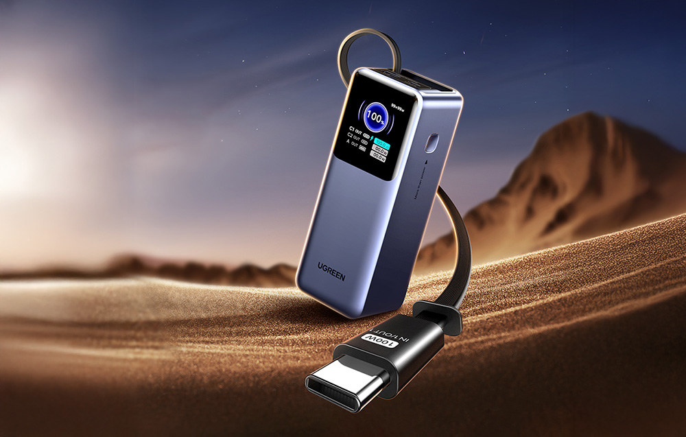 Powerbank Ugreen z wbudowanym kablem USB-C 100W zaprezentowany na tle piaszczystych wydm.