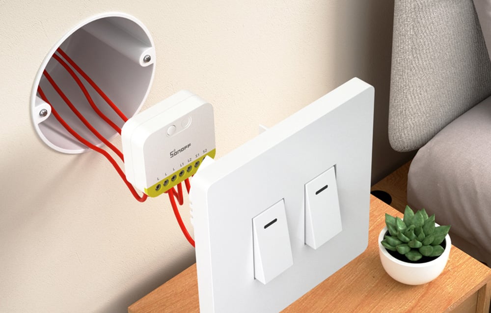 Mini przełącznik Sonoff zamontowany w puszce instalacyjnej za włącznikiem światła