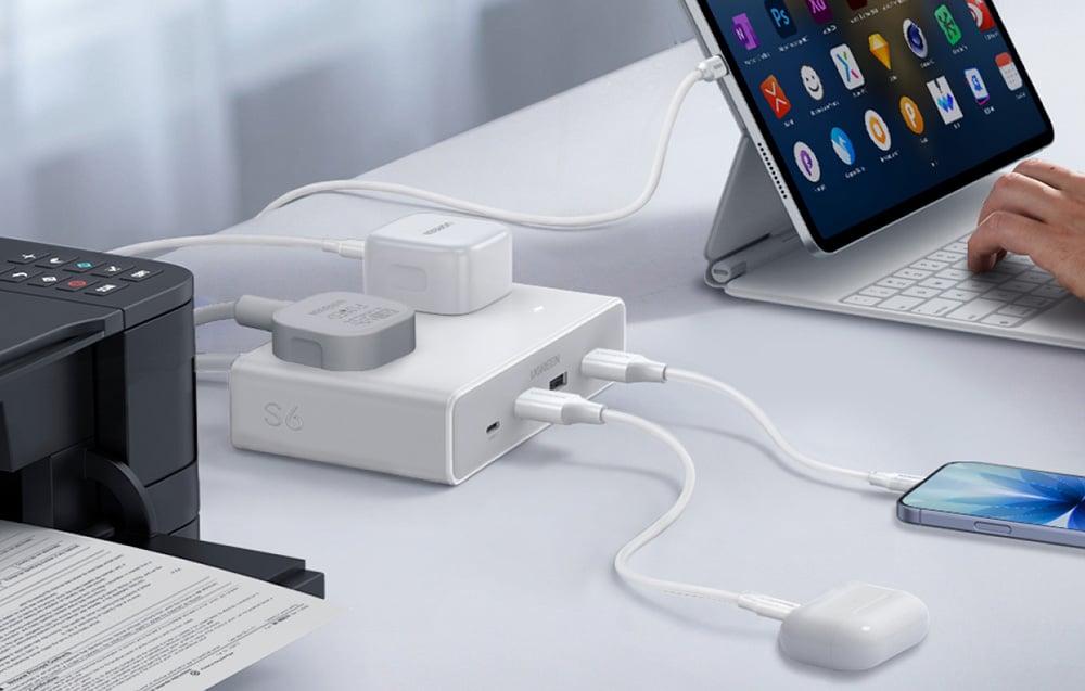 Biurkowa stacja ładowania z wieloma kablami zasilająca jednocześnie tablet, drukarkę, telefon i słuchawki.