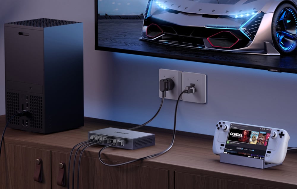Przełącznik Ethernet Ugreen pod telewizorem obok konsoli