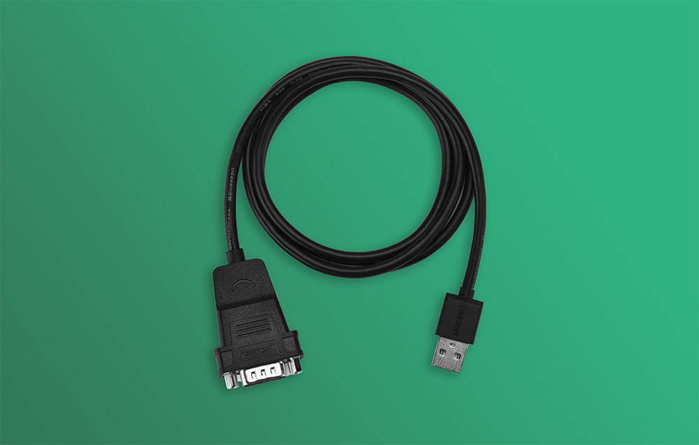 Zwinięty czarny kabel USB do DB9 na zielonym tle