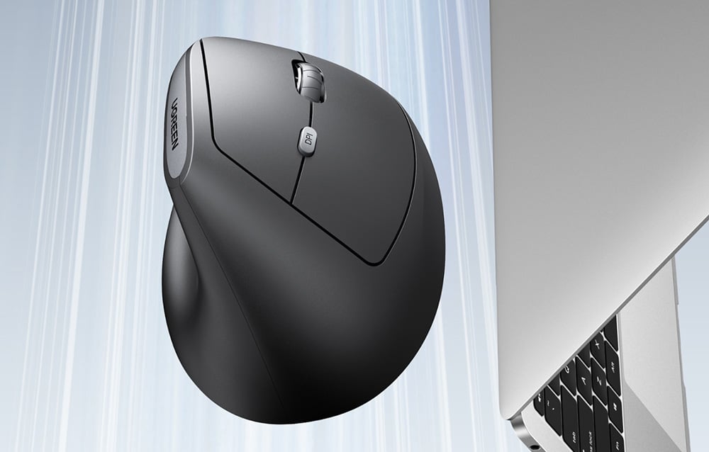 Zbliżenie na pionową ergonomiczną mysz komputerową UGREEN obok laptopa.
