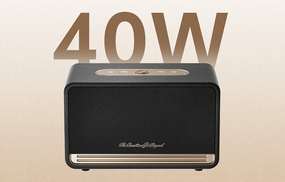 Czarny głośnik ze złotymi akcentami na jasnym tle, na górze brązowy napis 40W