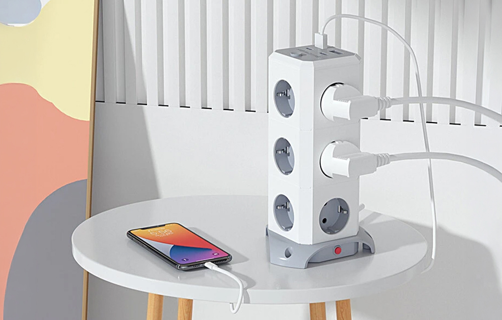 Power strip on a table next to a smartphone connected to charging