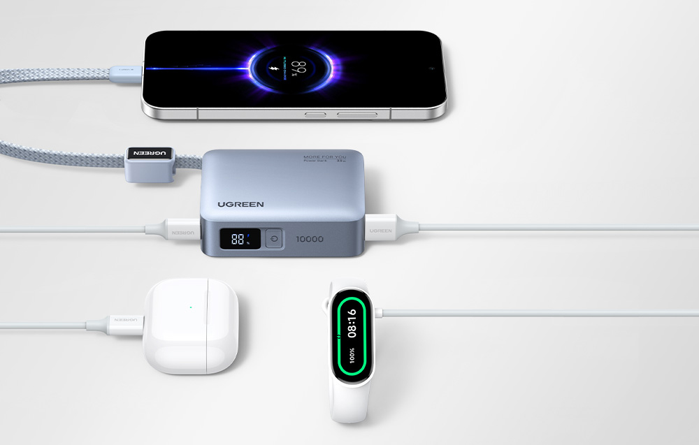 Szary powerbank Ugreen podłączony do trzech urządzeń - smartfonu, słuchawek i smartwatcha