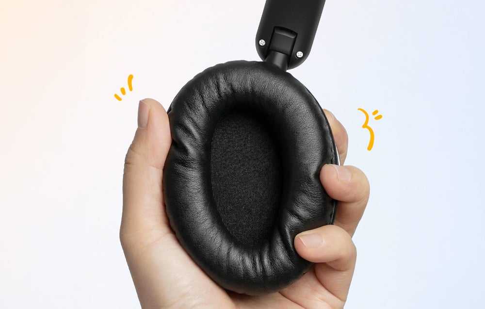 Dłoń ściskająca czarny nausznik słuchawek na jasnym tle