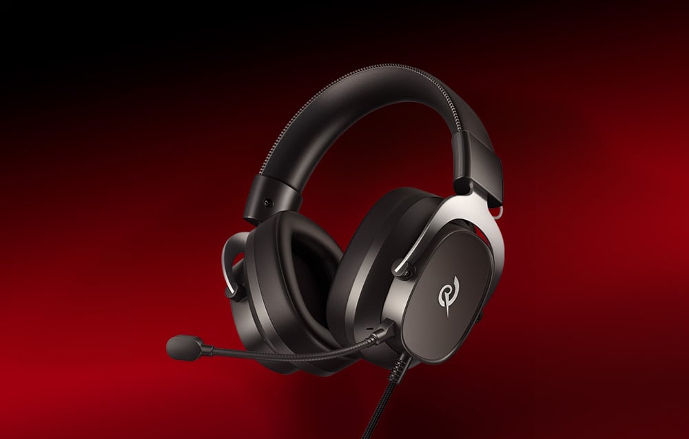 Czarne słuchawki gamingowe z mikrofonem na pałąku, ustawione pod kątem na jednolitym czerwonym tle