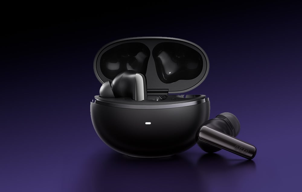 Otwarte czarne etui ładujące z jedną słuchawką w środku i drugą leżącą obok, na fioletowym tle