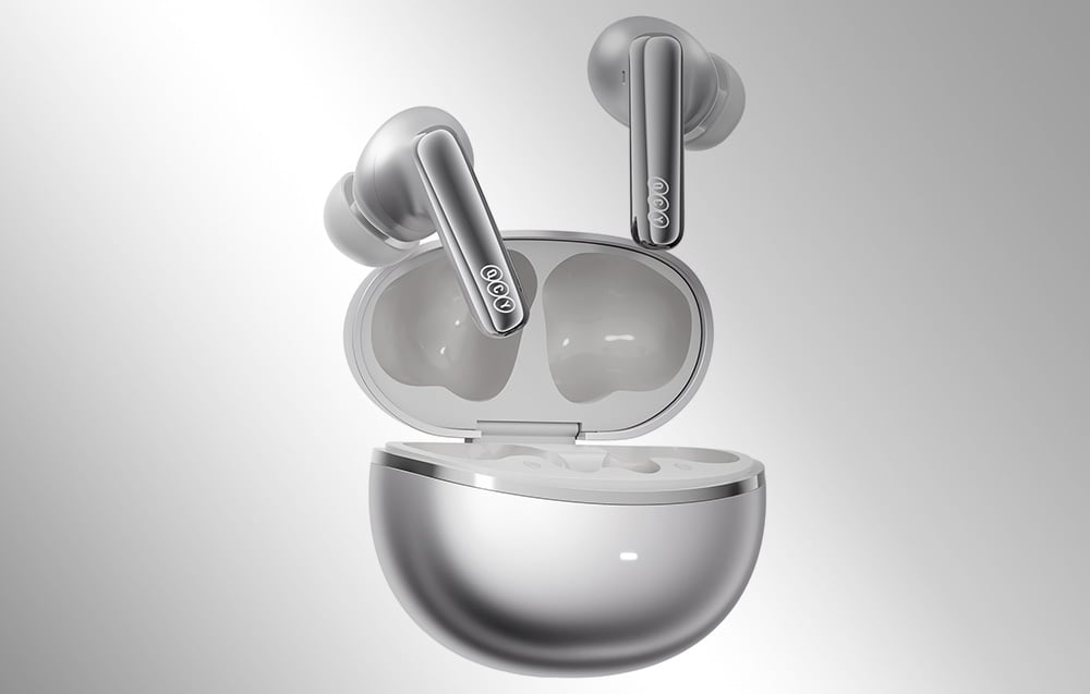 Srebrne słuchawki bezprzewodowe unoszące się nad otwartym etui ładującym o metalicznym wykończeniu