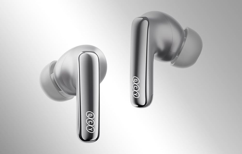 Dwie srebrne słuchawki bezprzewodowe z widocznym logo QCY, ukazane w zbliżeniu na szarym tle