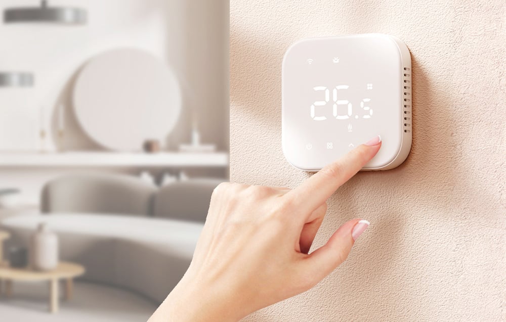 Biały inteligentny termostat Meross na beżowej ścianie w salonie