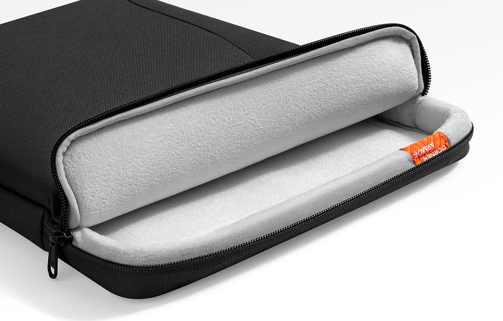 Etui na laptopa częściowo otwarte, pokazujące białą, puszystą wyściółkę wewnątrz