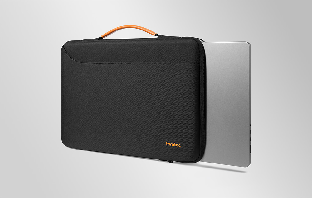 Czarna torba na laptopa tomtoc z pomarańczowym uchwytem, z której wysunięty jest srebrny notebook