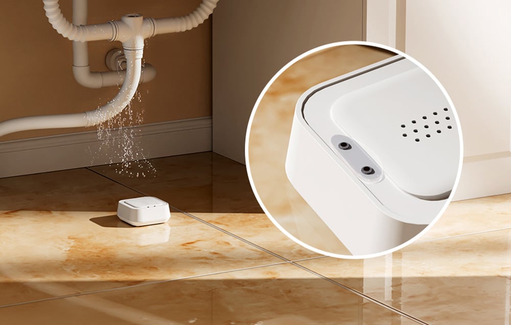 Intelligent water leak sensor MEROSS lying under a sink from which water is leaking