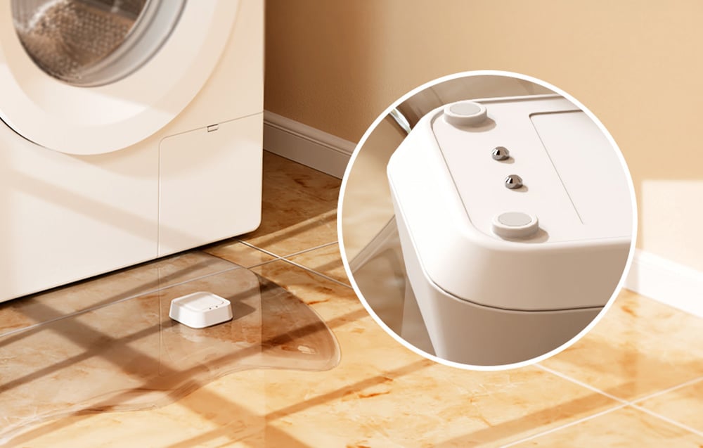 Intelligent water leak sensor MEROSS lying in a puddle of water next to a washing machine